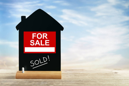 木質(zhì)背景上的銀色鑰匙與房屋頂部視圖符號(hào) 房地產(chǎn)廣告的視覺語言